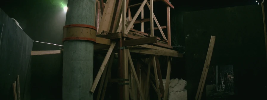 Timber formwork braced around a banded concrete column on a night site