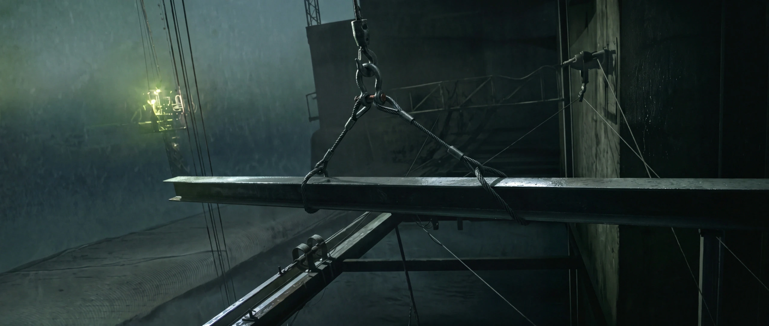 A steel beam hanging from a crane cable over a night site